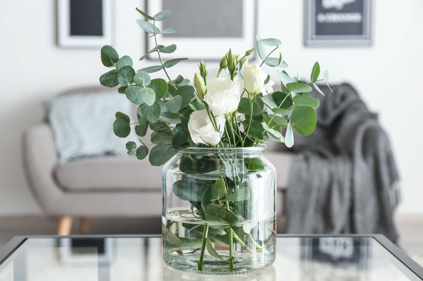 Vaas met mooie bloemen op tafel op kamer - Foto, afbeelding