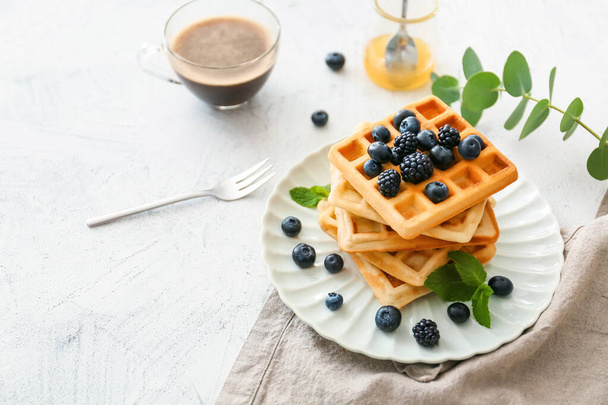 Plate with sweet tasty waffles on white table - Photo, Image