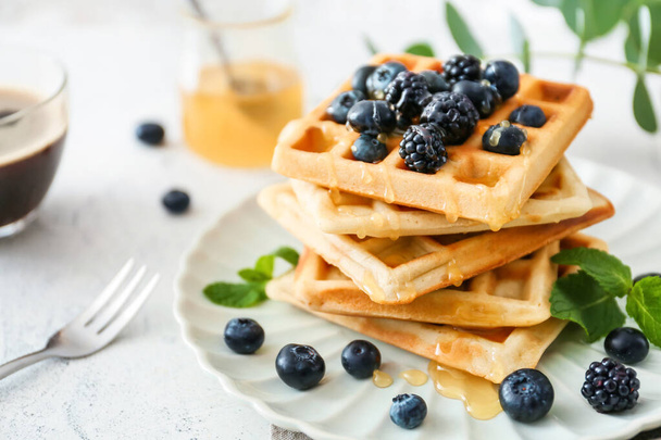 Plate with sweet tasty waffles on white table - Foto, Bild
