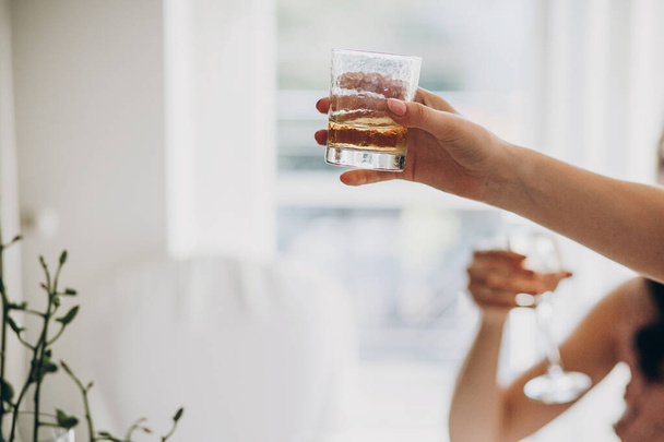 Hosté drží sklenici s whisky a tousty na svatební hostině - Fotografie, Obrázek