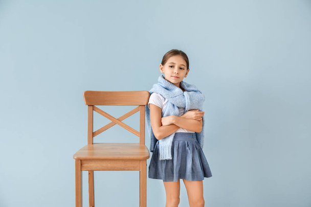 Χαριτωμένο μοντέρνο κορίτσι με καρέκλα στο φόντο χρώμα - Φωτογραφία, εικόνα