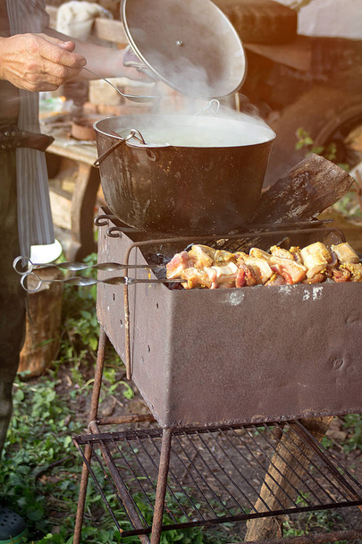 Рибний суп кипить у котлі на вогнищі. Кулінарний ароматний суп
 - Фото, зображення