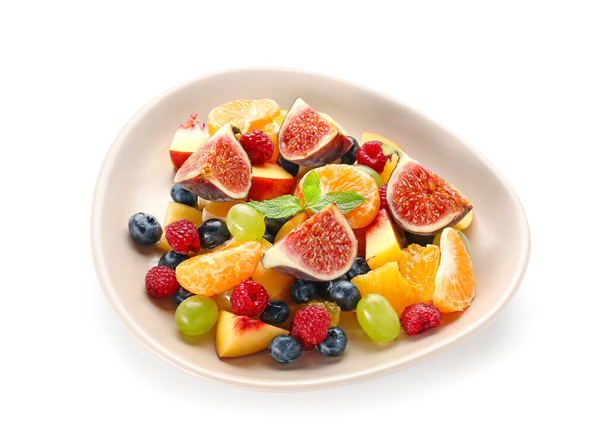 Bord met smakelijke fruitsalade op witte achtergrond - Foto, afbeelding