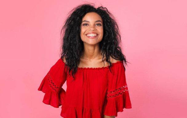 portrait of beautiful mixed race woman smiling and posing on pink studio background  - Photo, Image