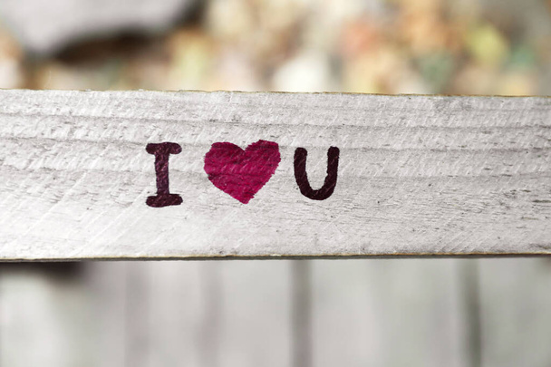 Фраза I LOVE YOU написана на деревянных перилах снаружи
 - Фото, изображение