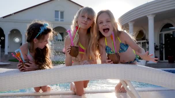 Μικρά με κοκτέιλ στα χέρια Βρέχει νερό στην πισίνα, Πλούσια κορίτσια στις καλοκαιρινές διακοπές Στη βίλα, ξεκουραστείτε στην πισίνα - Πλάνα, βίντεο
