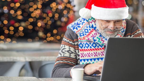 Modern Santa Claus using new technology for communications, buying presents online concept, receiving mail or wish list - Foto, Bild