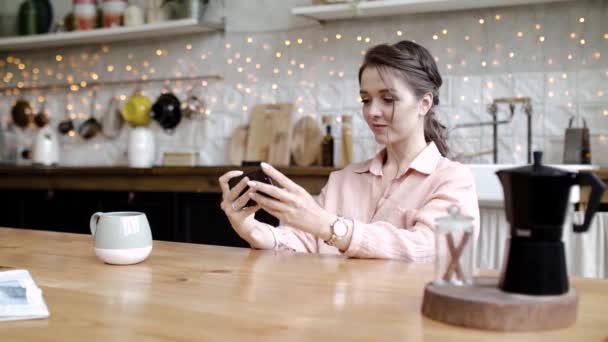 Young woman having fun playing phone on break. Stock footage. Stylish young woman fun and enthusiastically playing games on your smartphone during coffee break - Záběry, video
