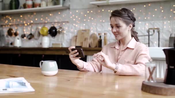 Young woman having fun playing phone on break. Stock footage. Stylish young woman fun and enthusiastically playing games on your smartphone during coffee break - Felvétel, videó