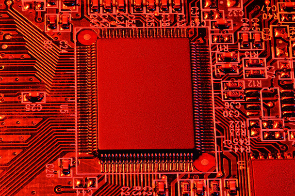 プリント基板とマイクロチップ、すなわちcpuは、赤のライトクローズアップで-デジタル機器用電子部品、電子計算機回路の開発のための概念 - 写真・画像