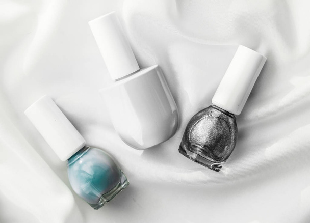 Nail polish bottles on silk background, french manicure products - Valokuva, kuva