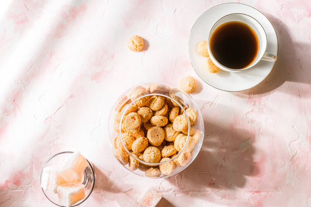 Biscuits aux amandes italiennes amaretti et une tasse de café noir sur fond rose
 - Photo, image
