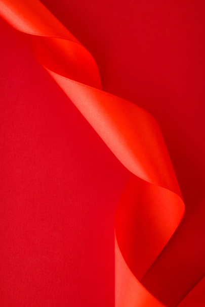 Abstract curly silk ribbon on red background, exclusive luxury b - 写真・画像
