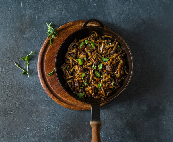 cogumelos fritos com ervas na panela de ato de fritar
 - Foto, Imagem