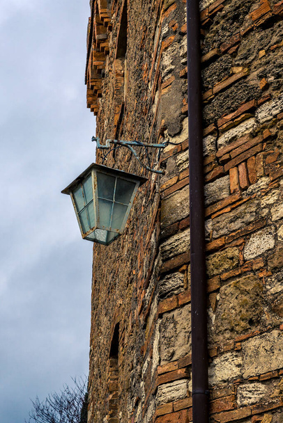 Old iron street lamp hanging on the side of wall - Φωτογραφία, εικόνα