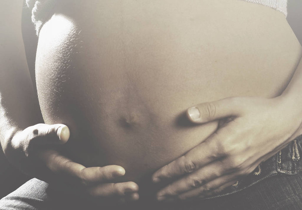 kobieta w ciąży delikatnie dotyka brzucha zawierającego jej małe dziecko - Zdjęcie, obraz