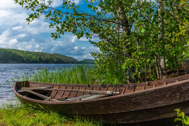 Old wooden rowing boat on the shore of the Saimaa lake in Finland - Valokuva, kuva