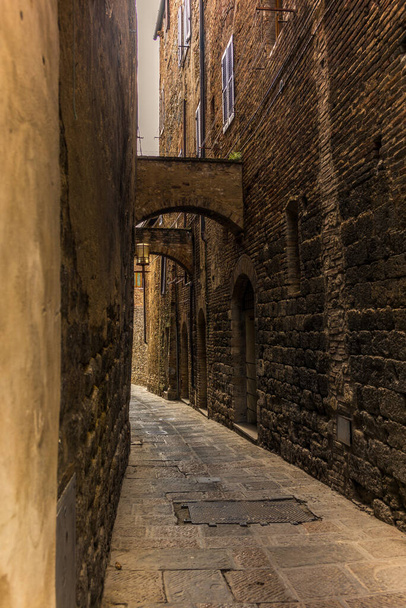 Small medieval street of San Gimignano in Tuscany - 写真・画像