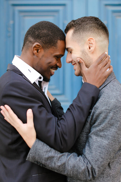 アフリカ系アメリカ人男性抱擁白人男の子でドアの背景. - 写真・画像