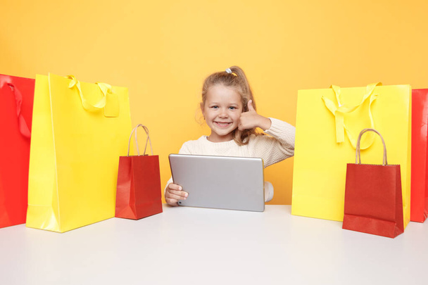 Pequeña blogger usando laptop y haciendo compras en línea
. - Foto, imagen