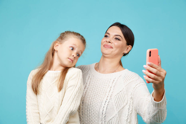 Funny portrait of mom and kid making photo together in the studio. - 写真・画像