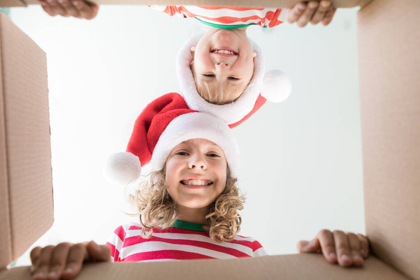 Surprised children unpack Christmas gift box - Фото, изображение