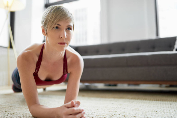 Trendy woman doing plank exercises as part of her fitness mornin - Photo, image