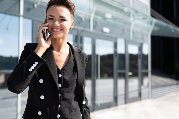 beautiful business woman posing outdoors with phone - 写真・画像