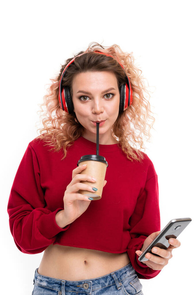 beautiful blonde girl with headphones, phone and coffee - Fotografie, Obrázek