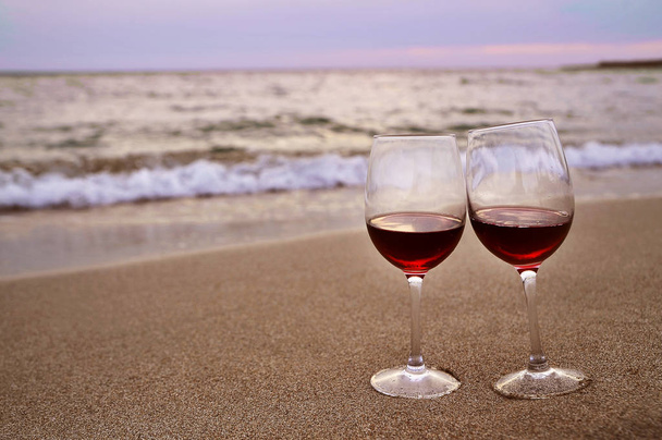 Dos copas de vino sobre arena, concepto de San Valentín
. - Foto, imagen
