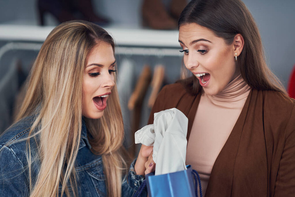 Mujeres adultas comprando ropa en boutique en otoño
 - Foto, Imagen