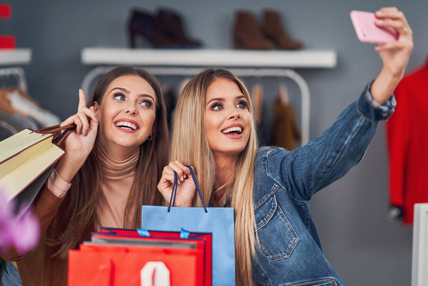 Felnőtt nők vásárolnak ruhát butikban ősszel - Fotó, kép