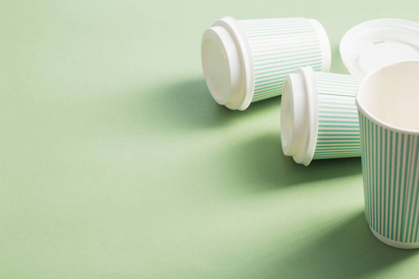 yeşil arka plan üzerinde kahve ile tek kullanımlık kağıt fincan - Fotoğraf, Görsel