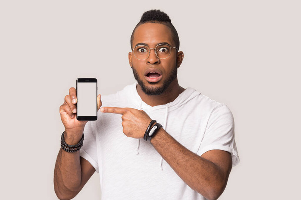 Shocked african American man show cellphone screen - Foto, afbeelding