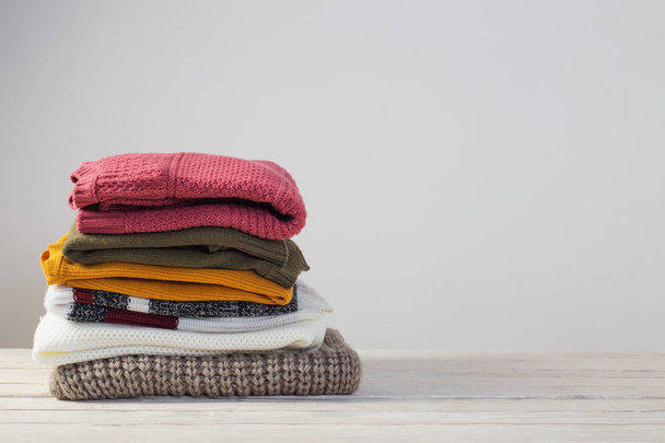 stack of sweaters on  white wooden table - Valokuva, kuva