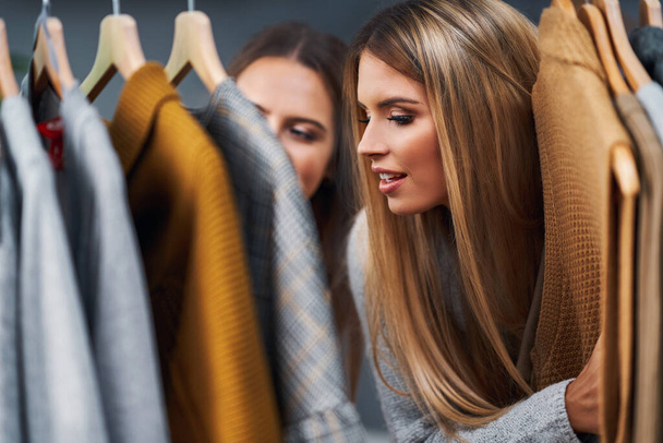 Mujeres adultas comprando ropa en boutique en otoño
 - Foto, imagen