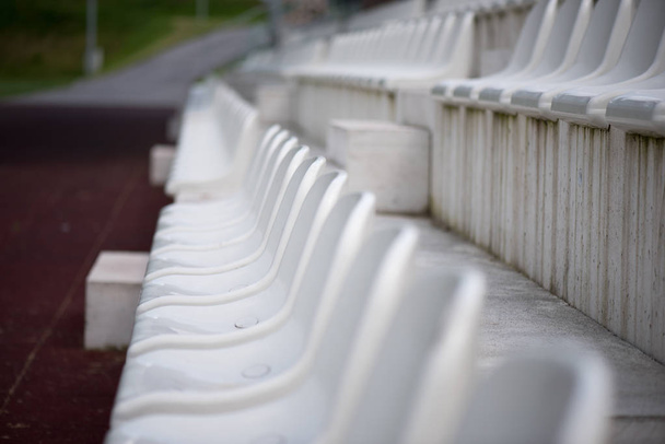スタジアムファンゾーンの白い席。小さなスポーツ競技場のグランドスタンドのファン。スポーツイベントの開催場所. - 写真・画像