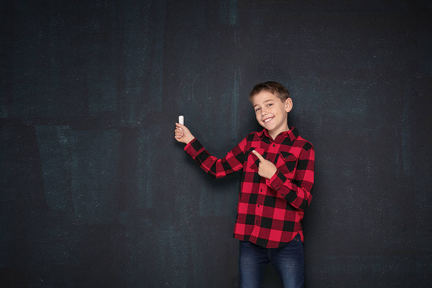 Teenage boy in checkered shirt over black chalk board. - Foto, Imagem
