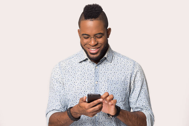 Happy biracial man using cellphone texting message - 写真・画像