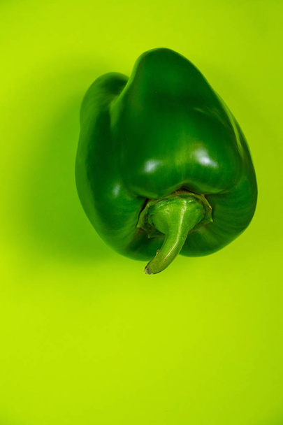 sweet ripe green peppers on a green background - 写真・画像
