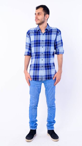 Full body shot of young bearded Persian hipster man thinking - Foto, imagen