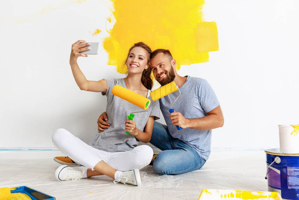 jovem casal feliz está reparando e pintura parede em hom
 - Foto, Imagem