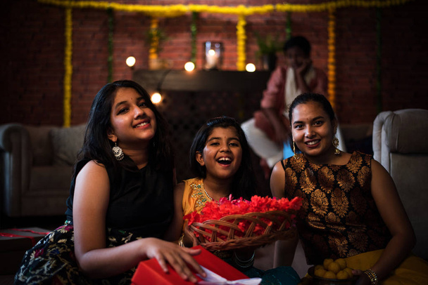 Niños indios celebrando Diwali / Deepawali, Bhai Dooj o Rakhi / Raksha Bandhan con flores, regalos, diya
 - Foto, imagen