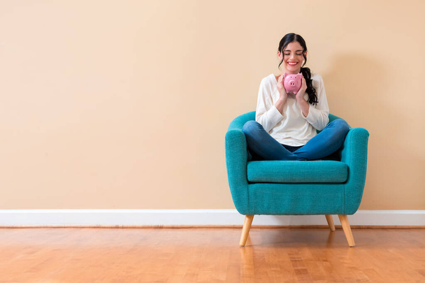 Young woman with a piggy bank - Foto, Imagen