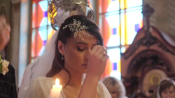 Крупный план портрета невесты в православной церкви во время свадебной церемонии
. - Кадры, видео