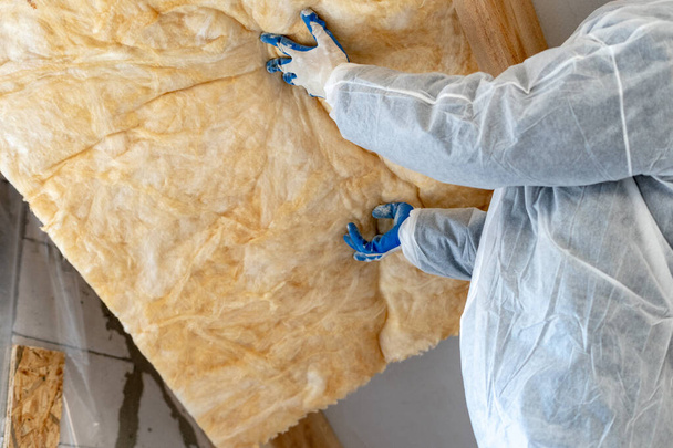 Handwerker installieren Wärmedämmung Steinwolle unter dem Dach - Foto, Bild