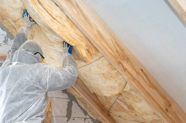 Handwerker installieren Wärmedämmschicht unter dem Dach - Foto, Bild