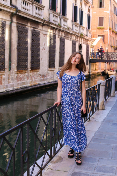Молодая туристка, стоящая у перила в Венеции, Италия
. - Фото, изображение