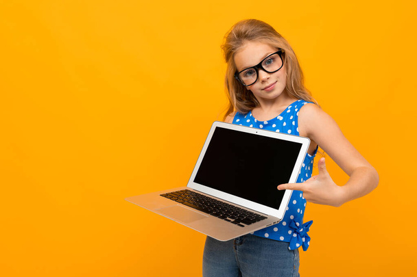 bambina in posa con occhiali e laptop sullo sfondo arancione
  - Foto, immagini