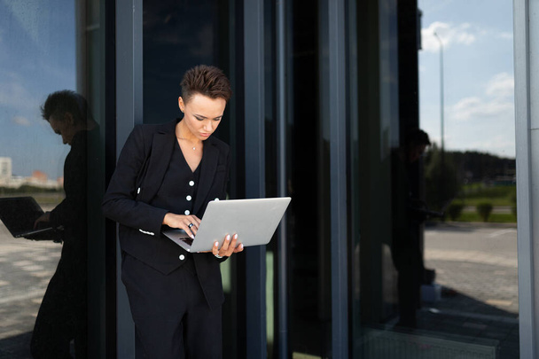Außenporträt einer jungen schönen Geschäftsfrau mit Laptop  - Foto, Bild